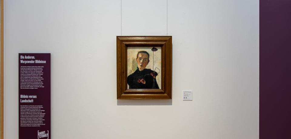 PMB ShortStories2025 Blick in Saal3 mit Brustbild einer Frau mit Mohnblume von 1898 72dpi 1000x1500px Foto Patric Leo Blick in Saal 3 mit dem Gemälde "Brustbild einer Frau mit Mohnblume" (1898) von Paula Modersohn-Becker © Foto: Patric Leo